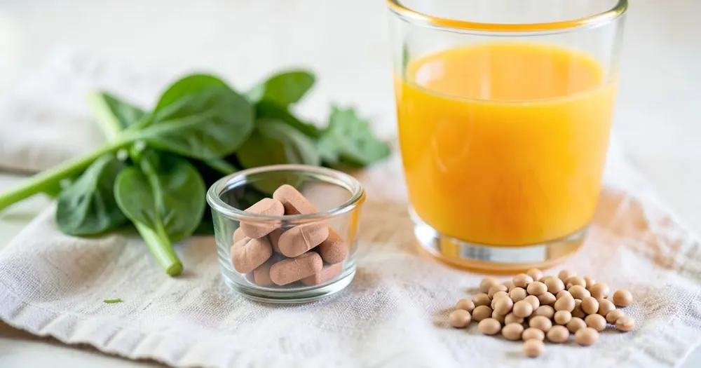 Iron tablets in a small glass dish beside orange juice, spinach and lentils Iron tablets in a small glass dish beside orange juice, spinach and lentils