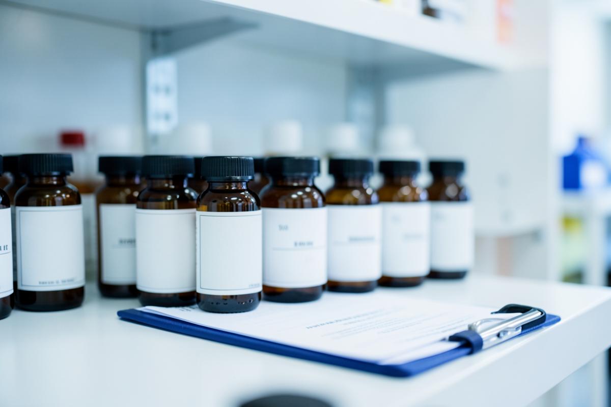A hospital pharmacy shelf with unlabelled amber bottles and a clipboard