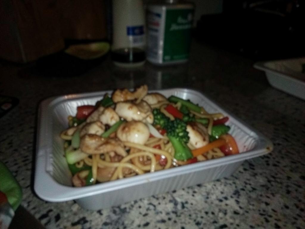 Dim, slightly blurry photo of a noodle stir fry in a takeaway container Dim, slightly blurry photo of a noodle stir fry in a takeaway container