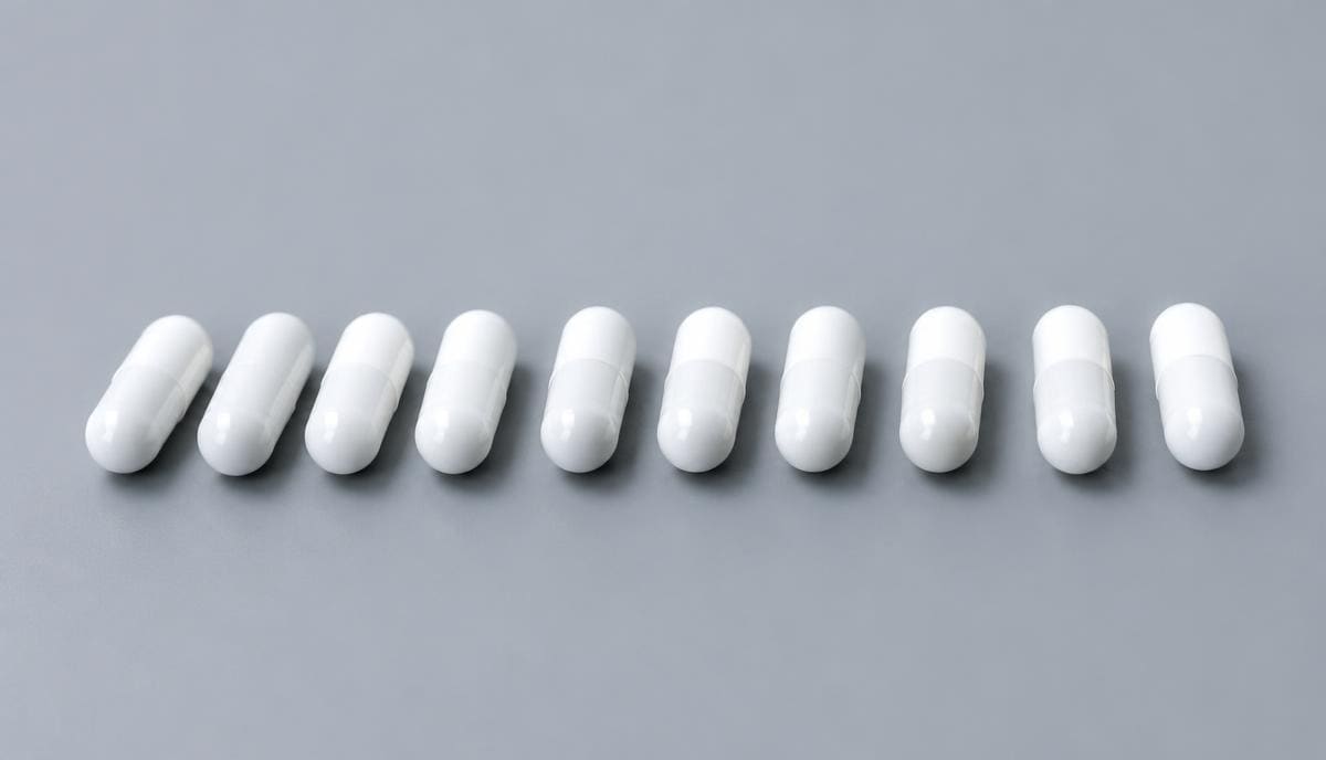 DoseRoutine CDP-Choline White capsules beside fine white powder on a grey surface