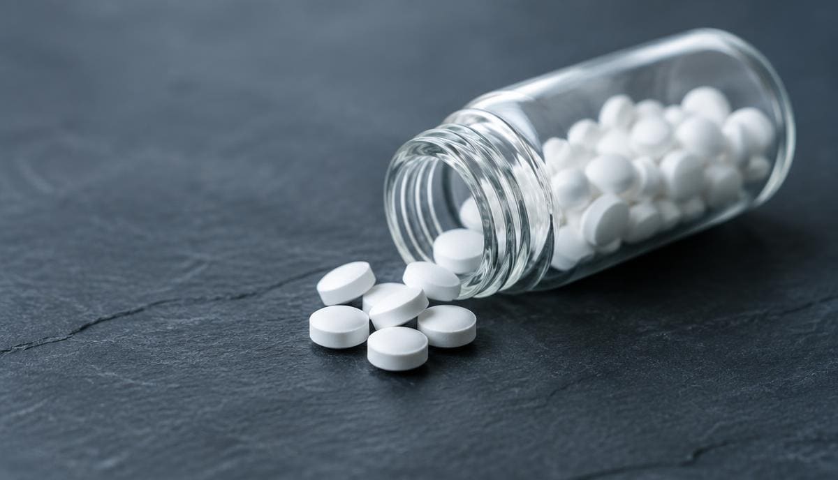DoseRoutine Lithium Orotate Small white lithium orotate tablets spilling from a glass vial